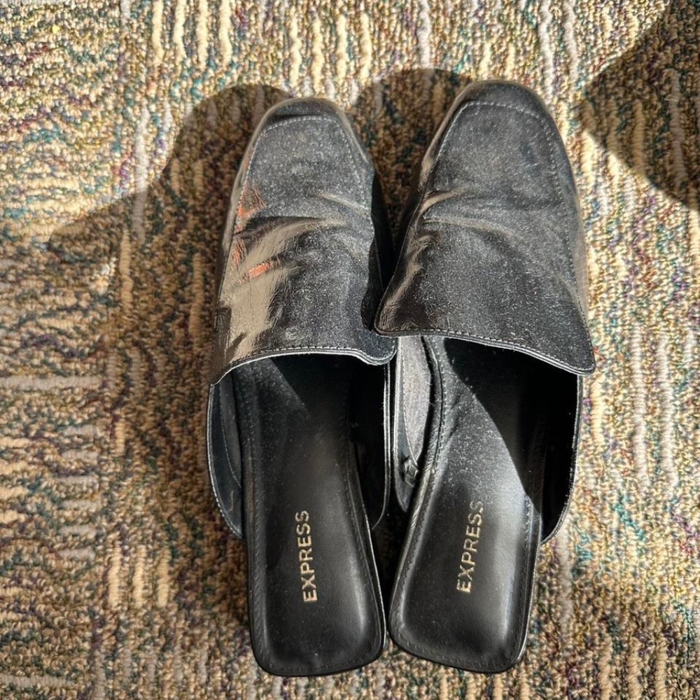 Express black slip on mules.